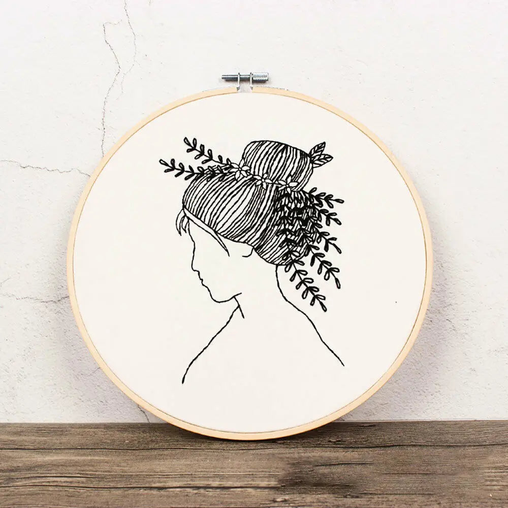 Black line drawing of a woman's profile with hair styled in an intricate braid and adorned with leafy vines.