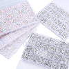A collection of acrylic letter beads in various colors and shapes stored in a grid box for jewelry making