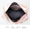 Pink iridescent duffel bag showing interior organization with separate compartments for dry and wet items