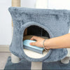 A hand is using a blue pet hair removal brush inside the opening of a gray, fuzzy pet toy.