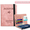 Pink RFID blocking passport cover and travel wallet with a black strap and a leather-like finish.