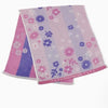 A folded pink and purple striped cotton face towel with a floral embroidery pattern.