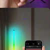 A hand holds a smartphone displaying an RGB color palette, with a vibrant light beam illuminating a room.