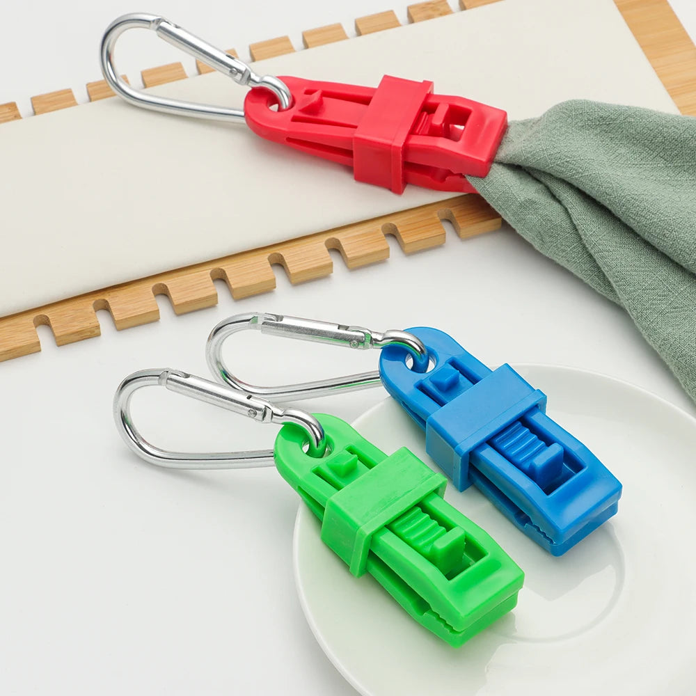 A set of durable glove clips in red and green plastic are shown resting on a white plate.