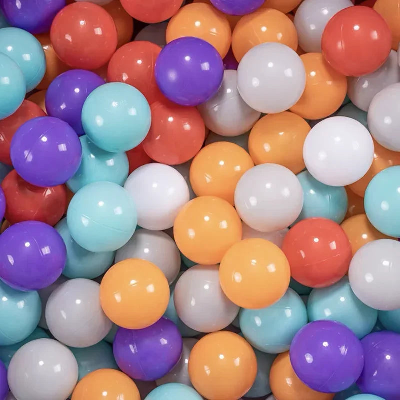 A large collection of colorful plastic balls in various shades including orange, purple, blue, and white.