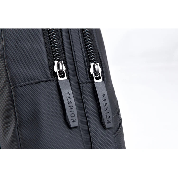 Close-up of a black men's adjustable crossbody chest bag featuring silver zippers and fashion branding.
