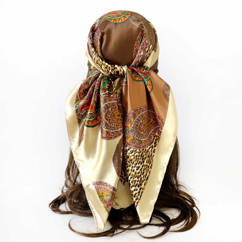 A square scarf featuring a leopard print and paisley pattern in shades of brown, gold, and orange.