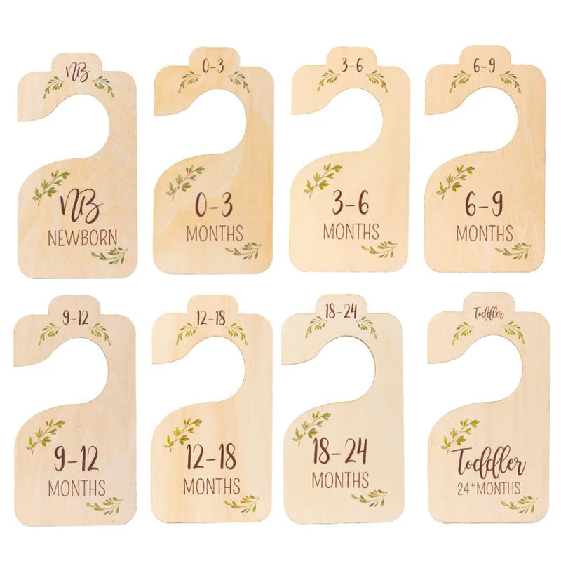 A set of wooden baby closet dividers with size labels for newborn to toddler months