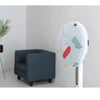 A white dust cover for an electric fan is displayed next to a gray upholstered chair.
