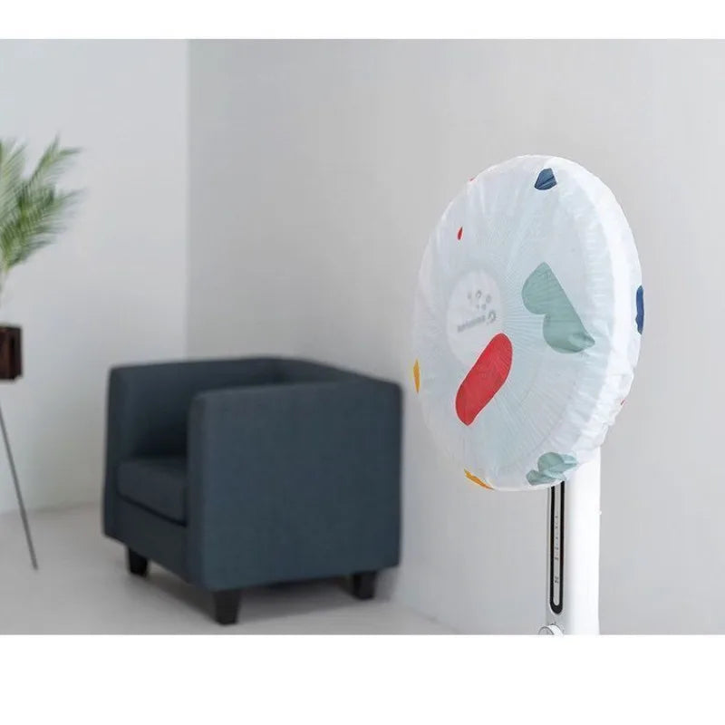 A white dust cover for an electric fan is displayed next to a gray upholstered chair.