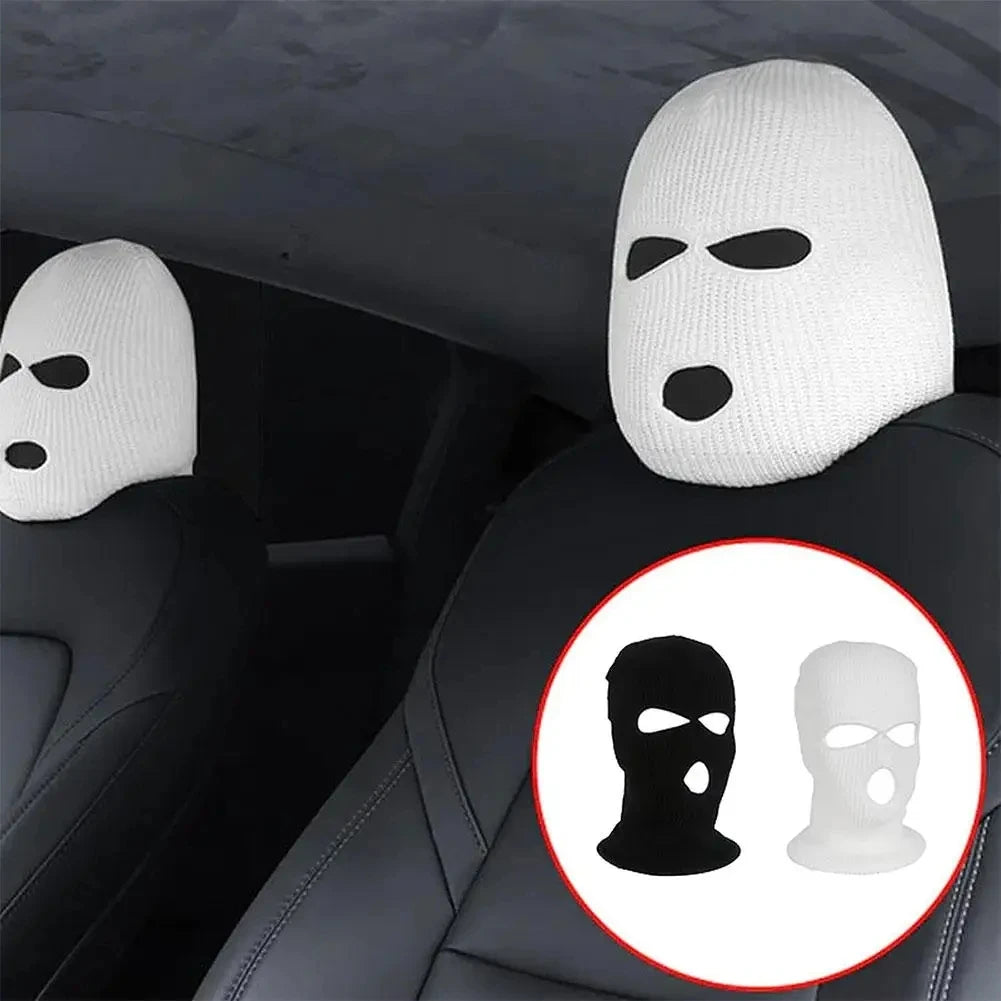 White ski mask car headrest covers installed on a black car seat.