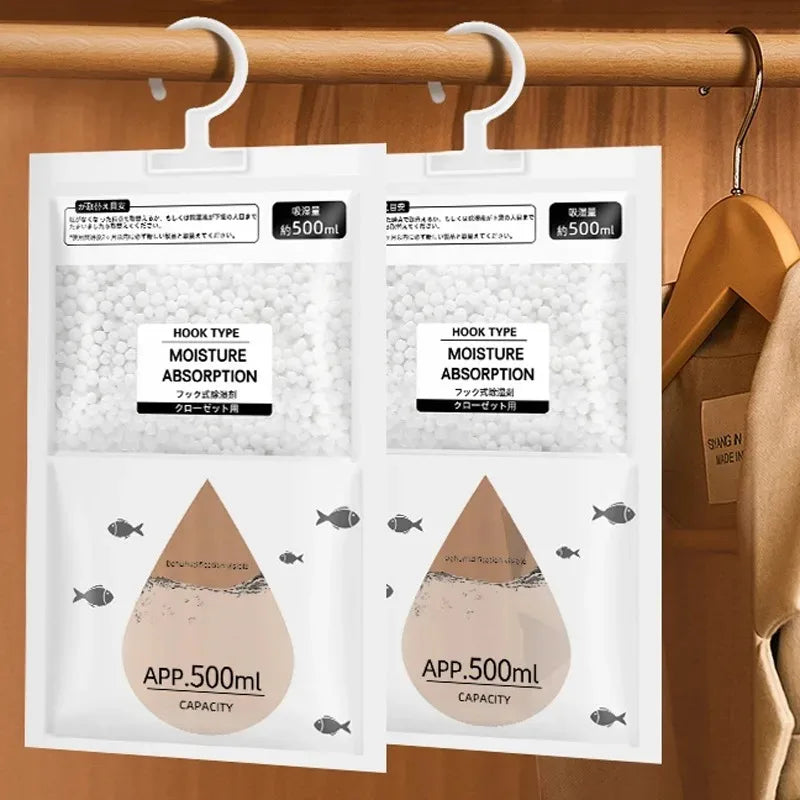 Two white moisture absorber hanging bags with hooks displayed on a wooden rod.
