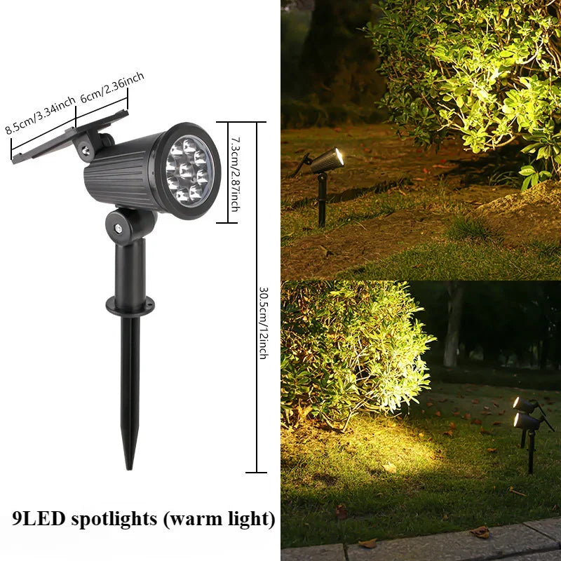 A black LED spotlight mounted on a pole, illuminating a green outdoor garden area.