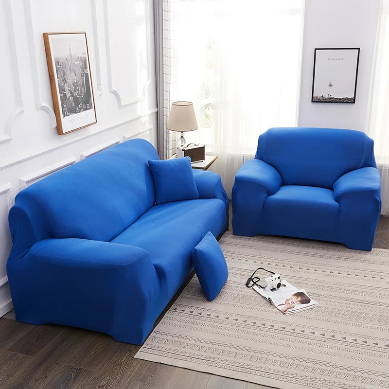 A bright blue silky soft stretchable sofa cover displayed on a sofa and armchair in a well-lit room.