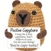 A handcrafted crocheted plush bear ornament with brown fur and black eyes.