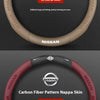 A close-up view of a brown steering wheel cover with Nissan branding and a red carbon fiber pattern.