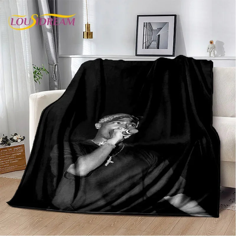 A black throw blanket featuring a silhouette of Eminem and 2Pac.