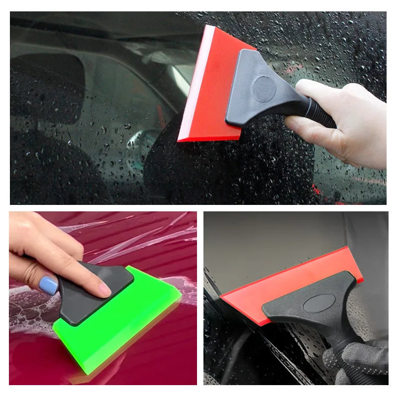 A hand is using a red and black car window squeegee to clean a car window.