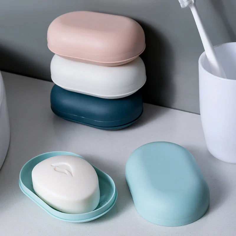 A stack of pink, white, and blue portable soap containers with a single light blue container in the foreground.
