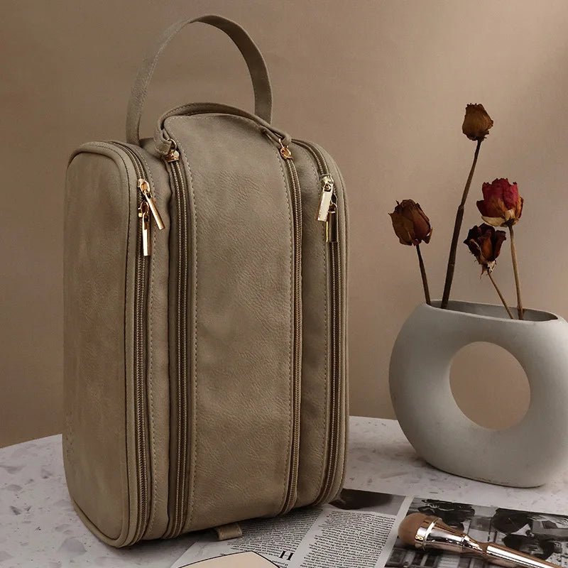 A beige waterproof PU leather cosmetic bag standing on a white surface.