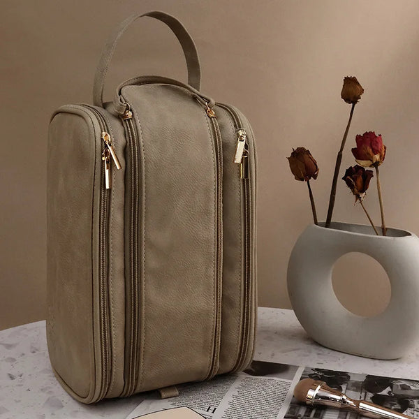 A beige waterproof PU leather cosmetic bag standing on a white surface.