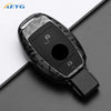 A black slim carbon fiber car key cover with a cutout for the key and two small openings.