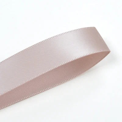 A roll of double face satin ribbon in a light mauve color shown diagonally.