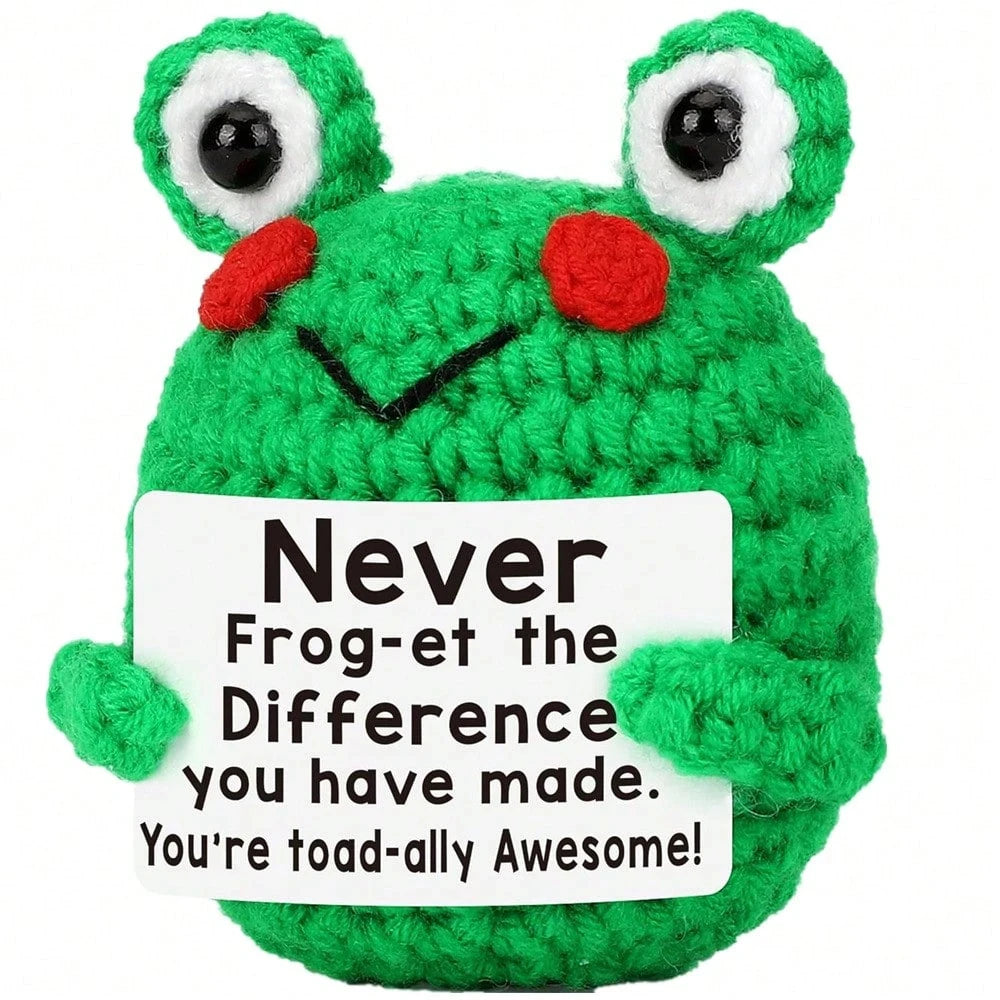 A bright green crocheted plush ornament shaped like a frog with large eyes and a smiling mouth.