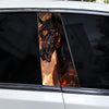 A close-up view through a car window showing a decal of a horse's head with glowing orange and red markings.