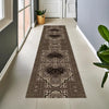 A long runner rug with vintage tribal geometric patterns in brown and cream tones placed on a light tile floor.