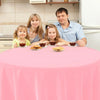 A family of four enjoying a meal around a pink round table in a kitchen setting.