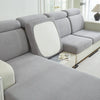 A light gray elegant stretch sofa slipcover with white cushions and a textured fabric.