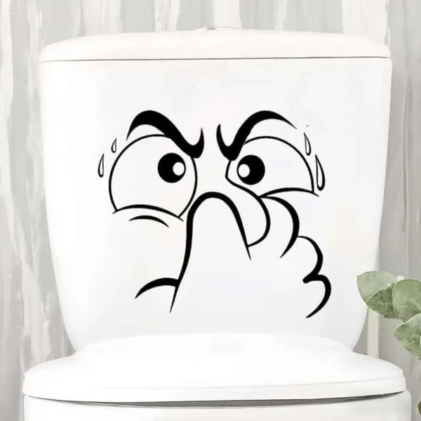 White toilet lid featuring a black sticker of an expressive, surprised face with water droplets.