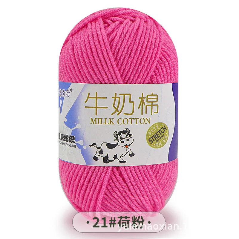 Pink milk cotton blend yarn skein with a label featuring a dog and stitching details