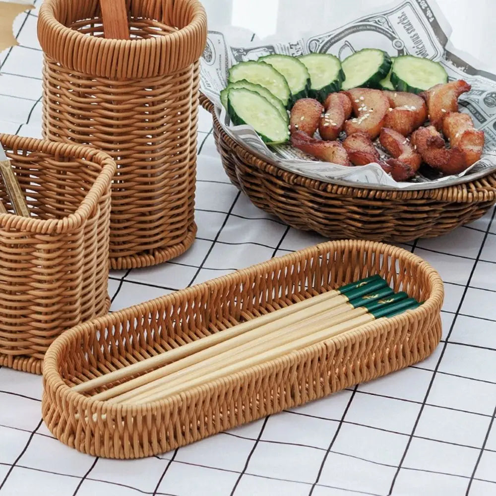 A collection of handwoven wicker serving baskets and bamboo chopsticks displayed on a white checkered surface.
