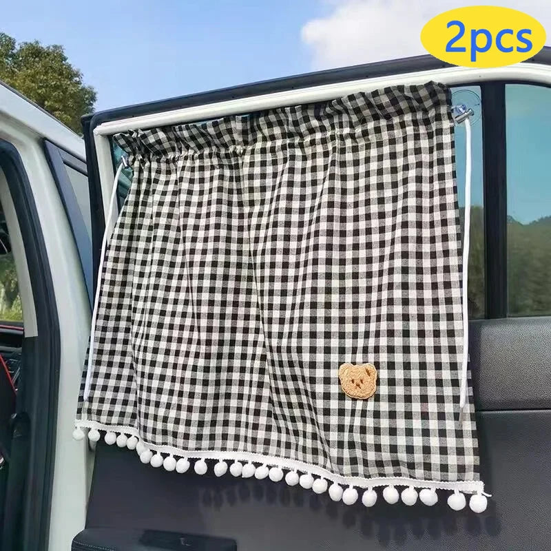 Black and white checkered sun shade curtains for a car window featuring a small bear charm