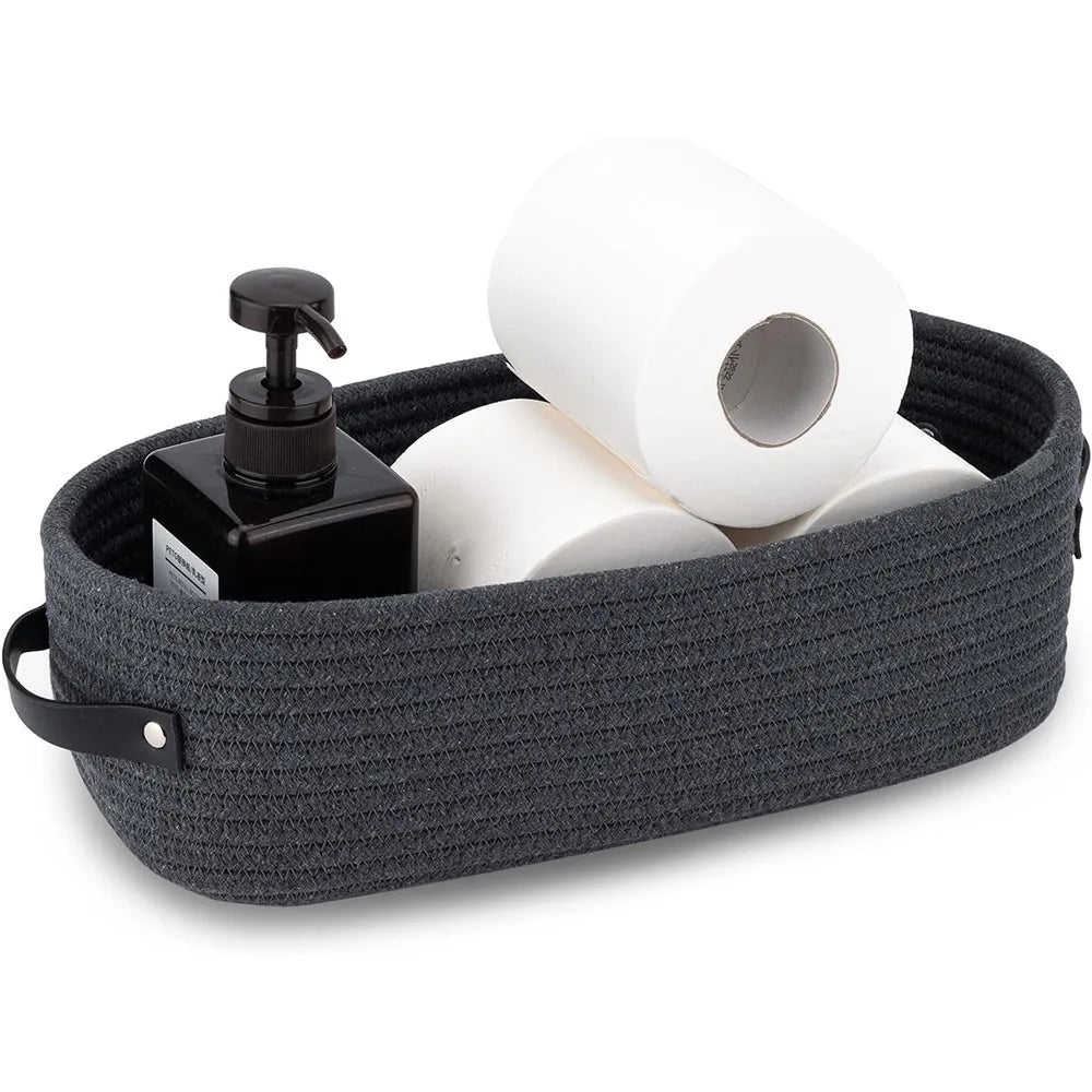 A dark gray woven cotton rope storage basket holding several rolls of white paper.