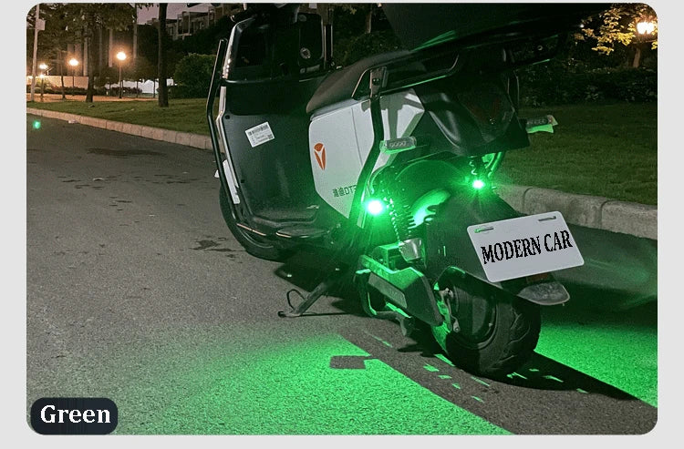 A black motorcycle is parked on the side of a road with green strobe lights illuminating the pavement.
