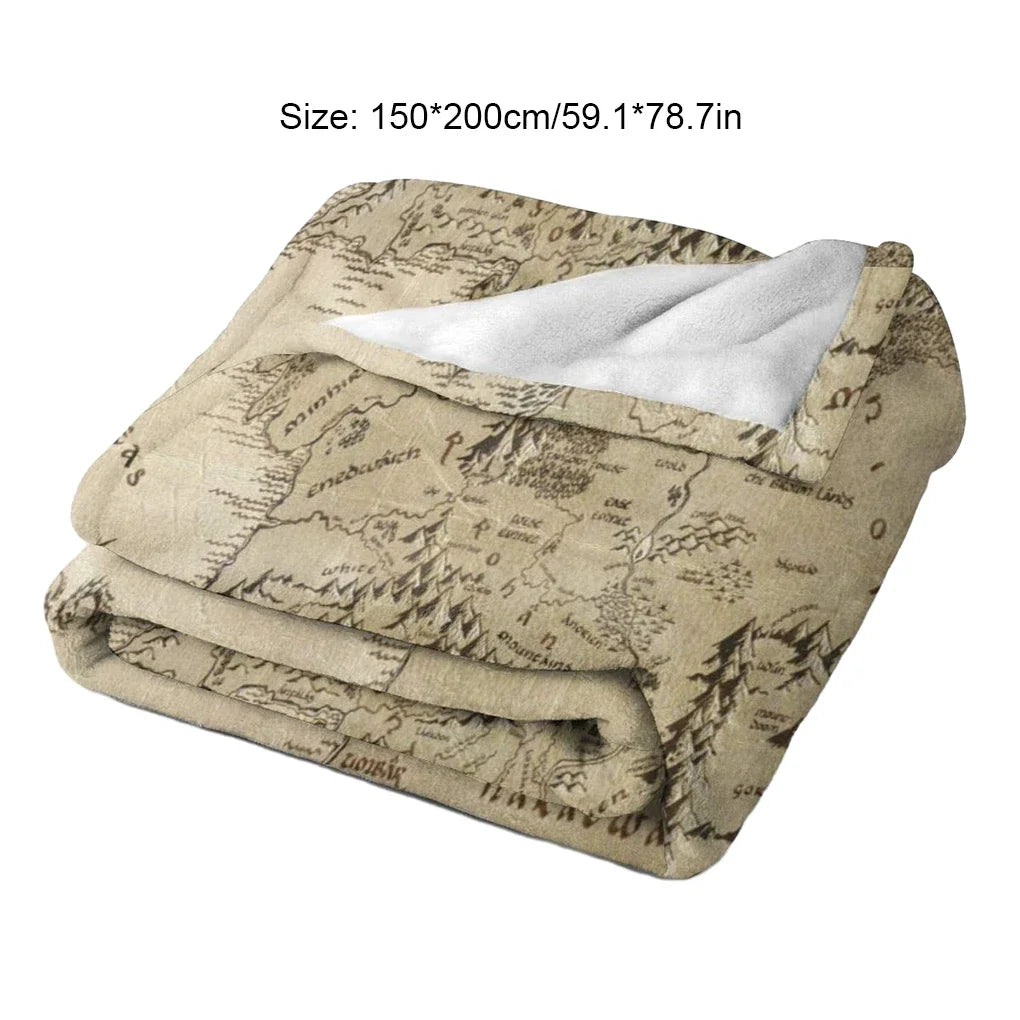 A beige plush throw blanket featuring a faded Middle Earth map design.