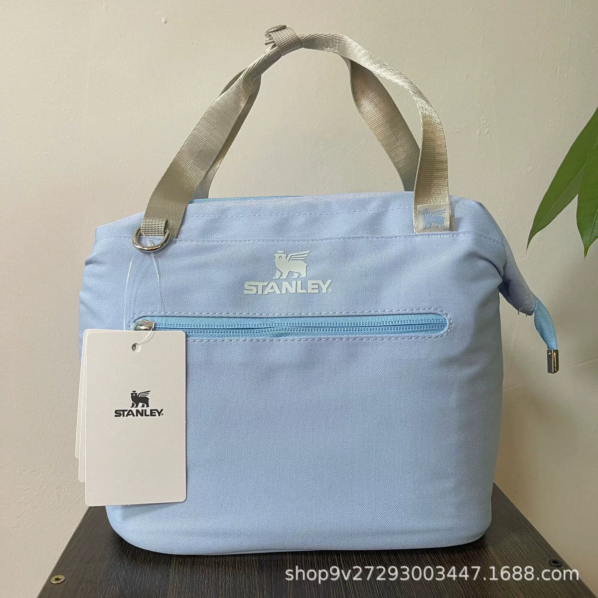 Light blue Stanley insulated crossbody cooler bag with a light gray strap and tag.