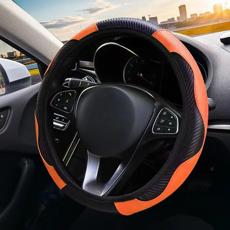 Close-up view of an orange and black steering wheel cover with a non-slip grip on a car's interior.