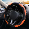 Close-up view of an orange and black steering wheel cover with a non-slip grip on a car's interior.