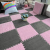 Pink and gray interlocking foam floor tiles with a purple striped pillow and a small vase of blue flowers