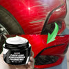 A hand holds a jar of Plastic Clean Scratch Remover Polishing Wax for auto paint repair against a red car body.