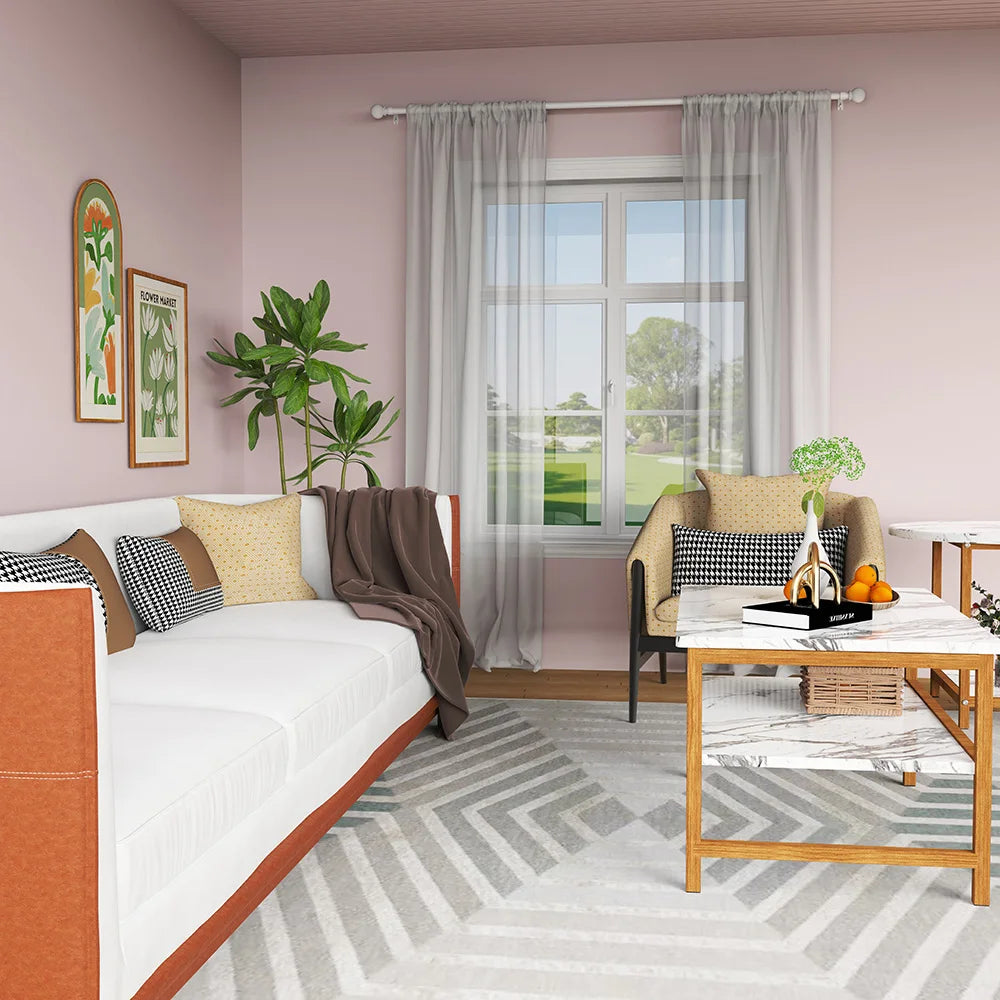 A light pink room features a white sofa, a wooden table, and a window with sheer curtains.