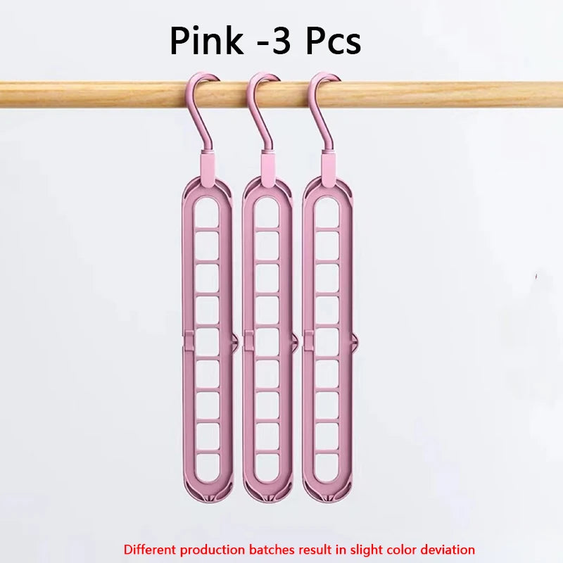 Three pink folding hangers with 9 holes are displayed hanging on a wooden rod.