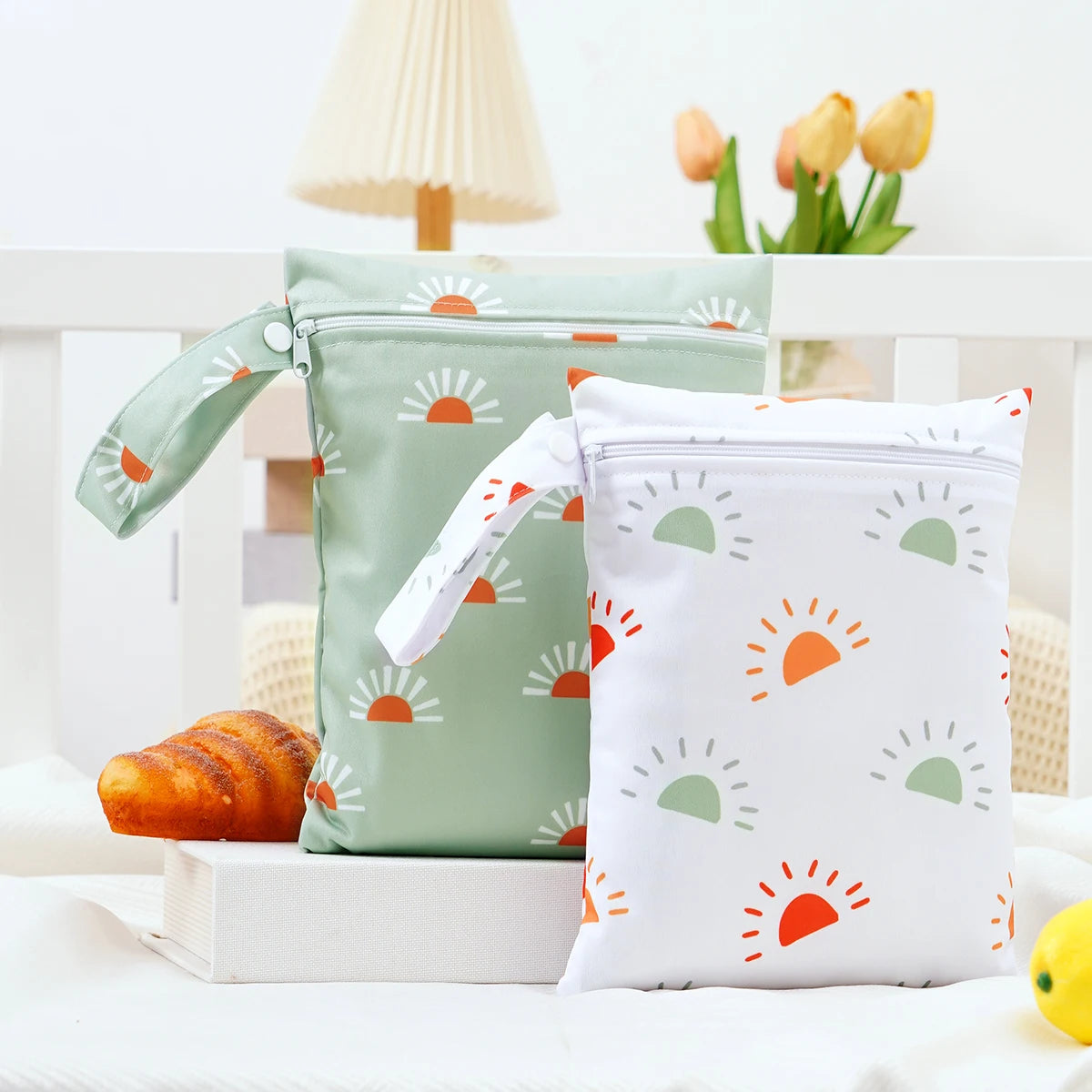 A pair of light green and white mini waterproof wet dry bags with sun-shaped designs are displayed on a white surface.