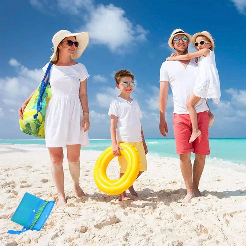 A family of three enjoying a beach day with a large yellow mesh tote bag.