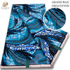 Blue and black African wax print fabric featuring feather patterns and geometric designs
