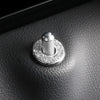 Close-up black leather surface showing a silver crystal rhinestone car door lock pull cover.